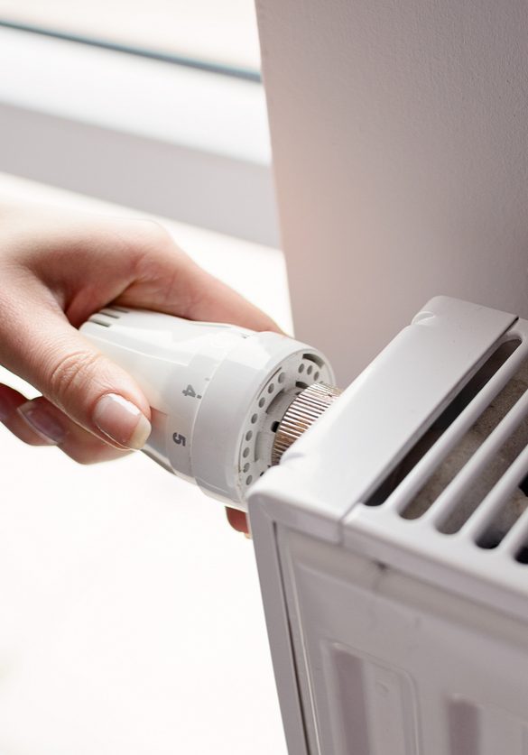 Closeup on woman's hand adjusting thermostat valve